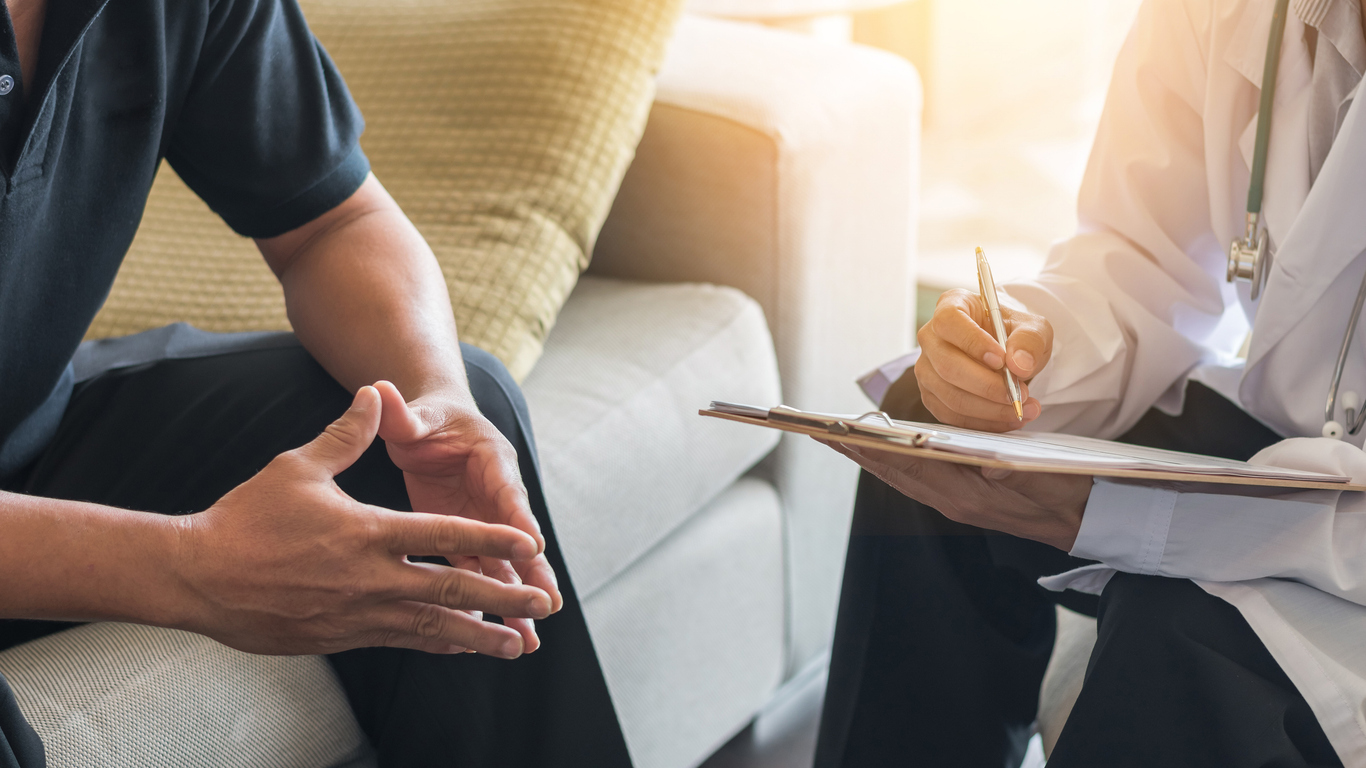 Doctor counseling a male patient on home detox / outpatient alcohol withdrawal management.